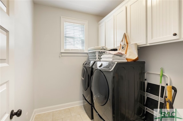 laundry area with washer and clothes dryer, cabinet space, light tile patterned flooring, and baseboards