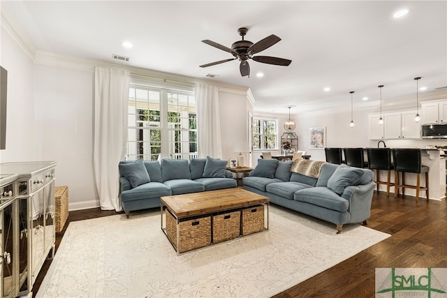 living room featuring ornamental molding, dark wood finished floors, recessed lighting, ceiling fan, and baseboards