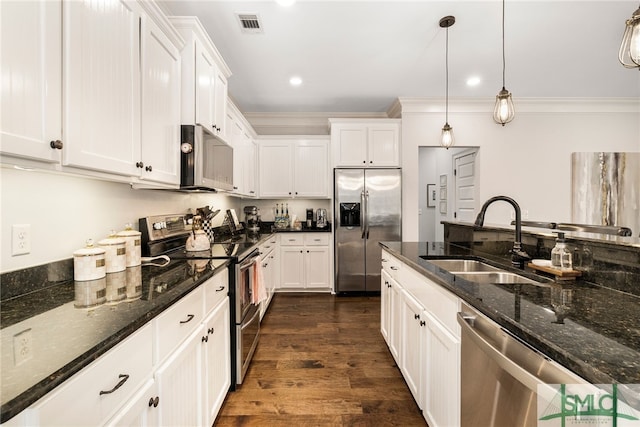 kitchen with appliances with stainless steel finishes, a sink, white cabinetry, ornamental molding, and dark wood-style floors