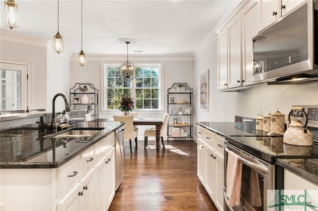 kitchen featuring stainless steel appliances, a sink, dark stone countertops, dark wood-style floors, and white cabinetry