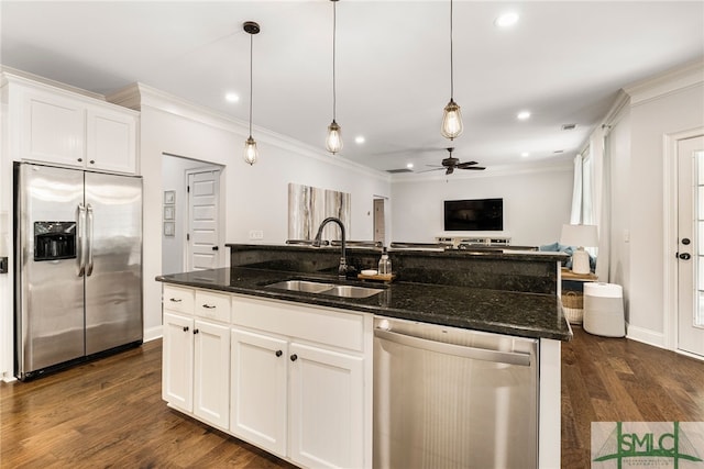 kitchen with appliances with stainless steel finishes, a sink, open floor plan, ceiling fan, and crown molding