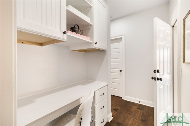 unfurnished office with dark wood-type flooring and built in study area