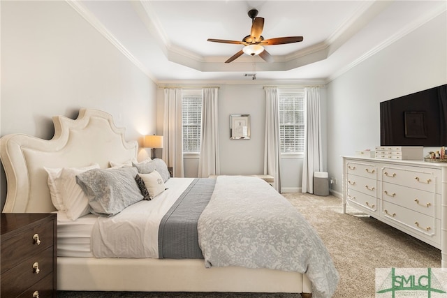 bedroom with crown molding, light carpet, a tray ceiling, ceiling fan, and baseboards