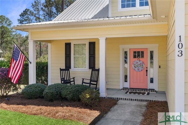 property entrance with covered porch and metal roof