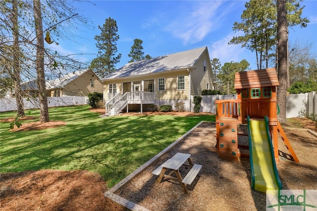 rear view of property featuring a playground and stairs