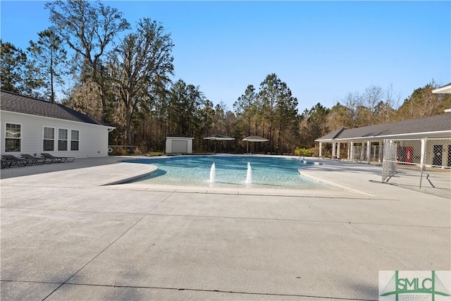 pool with a patio area and an outdoor structure