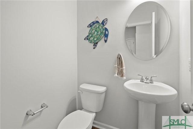 half bath with toilet and baseboards