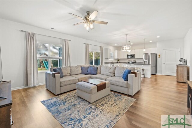 living area with baseboards, visible vents, recessed lighting, ceiling fan, and light wood-type flooring