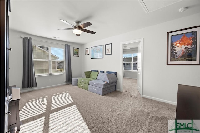 sitting room featuring baseboards, carpet floors, attic access, and a ceiling fan