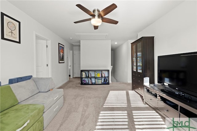 living room with baseboards, light colored carpet, attic access, and ceiling fan