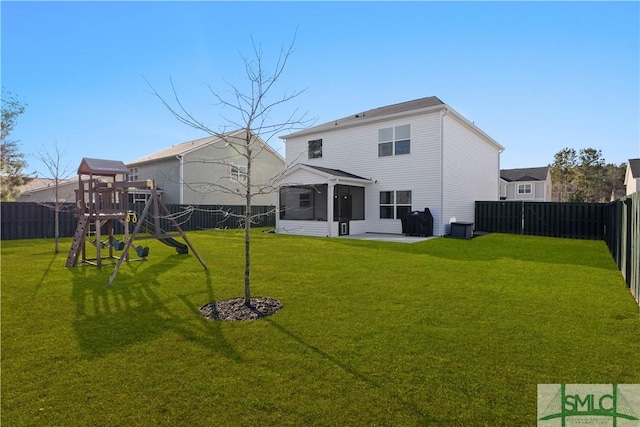 back of property featuring a yard, a playground, a fenced backyard, and a sunroom