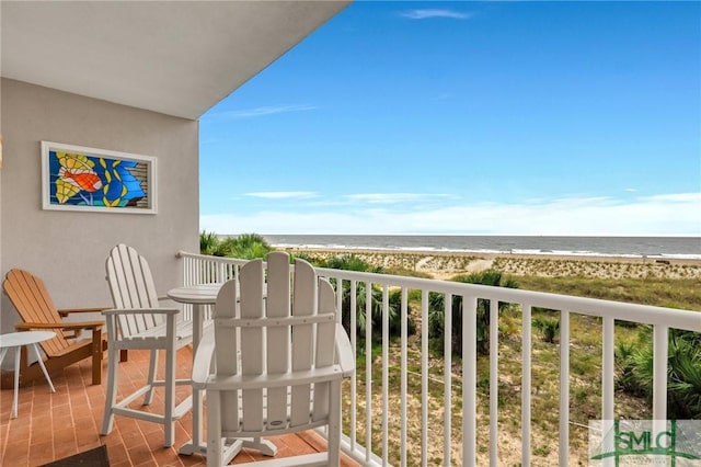 balcony featuring a beach view and a water view