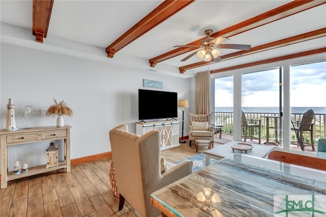 living room with beamed ceiling, baseboards, ceiling fan, and wood finished floors