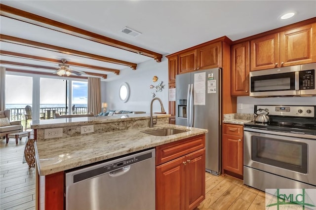 kitchen featuring a sink, stainless steel appliances, visible vents, and open floor plan