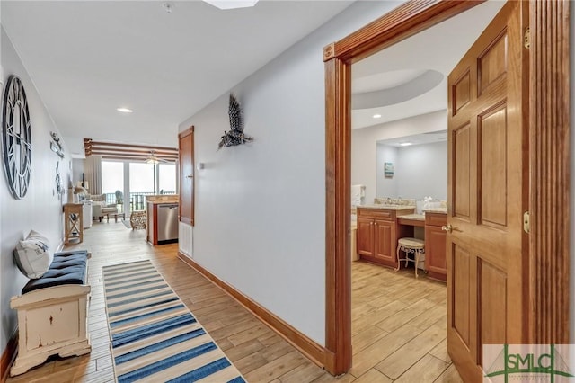 hall featuring recessed lighting, light wood-type flooring, and baseboards