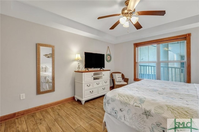 bedroom featuring baseboards, light wood-style floors, and ceiling fan