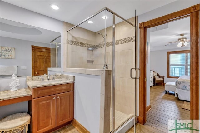 full bathroom with connected bathroom, a shower stall, wood finished floors, vanity, and a ceiling fan