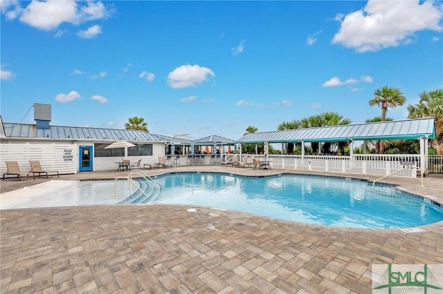 community pool featuring a patio and fence