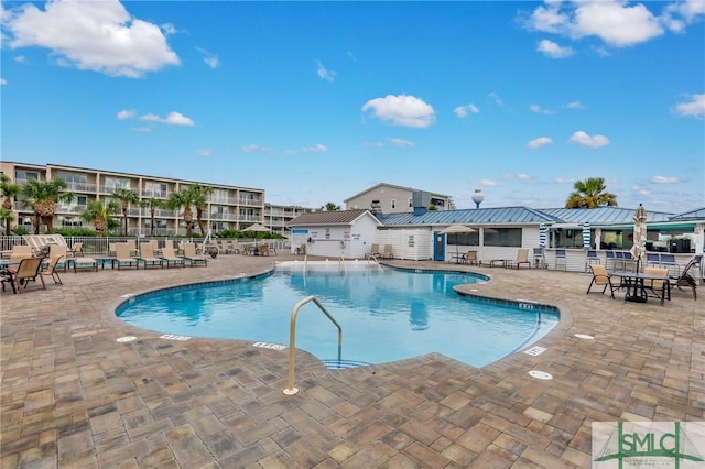 community pool with a patio and fence