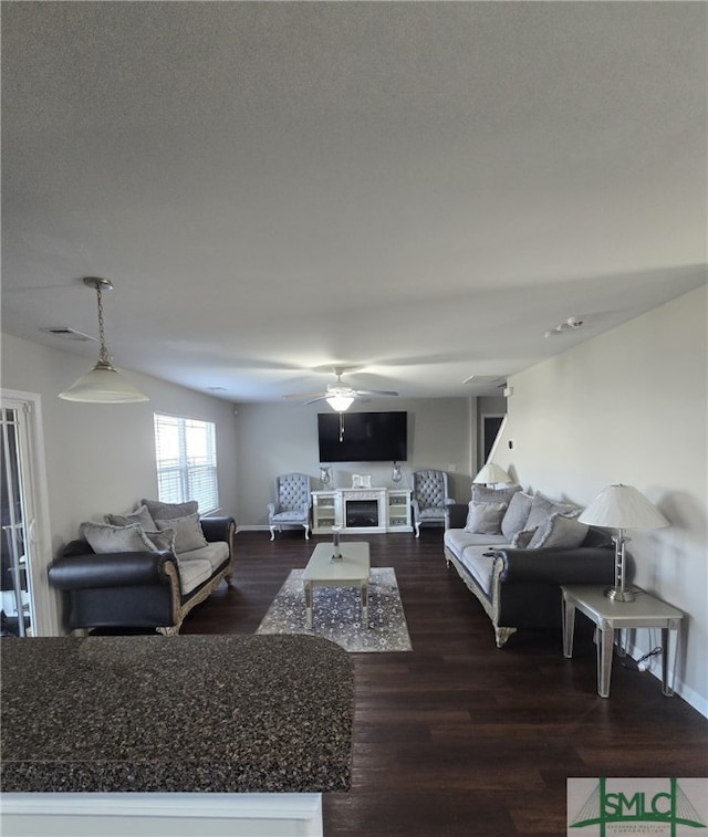 12 Noble Jones Ct, Port Wentworth, GA 31407 - living room featuring ceiling fan, dark wood-style flooring, visible vents, a fireplace, and baseboards