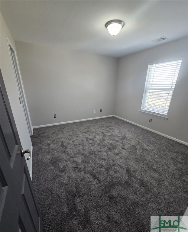 12 Noble Jones Ct, Port Wentworth, GA 31407 - empty room featuring visible vents, baseboards, and dark carpet
