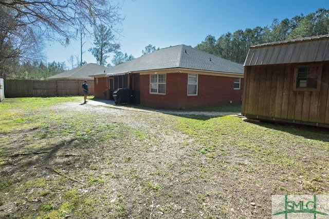 350 Clark St, Richmond Hill, GA 31324 - rear view of property featuring an outdoor structure, a storage unit, a fenced backyard, and a yard