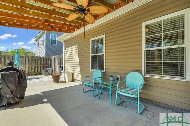 view of patio featuring fence, area for grilling, and ceiling fan