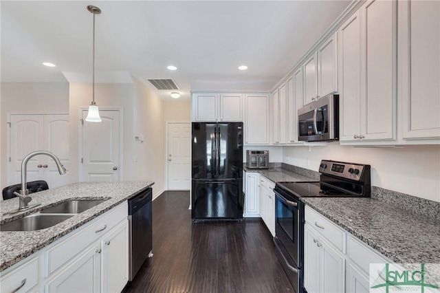 kitchen featuring pendant lighting, a sink, appliances with stainless steel finishes, visible vents, and dark wood-type flooring