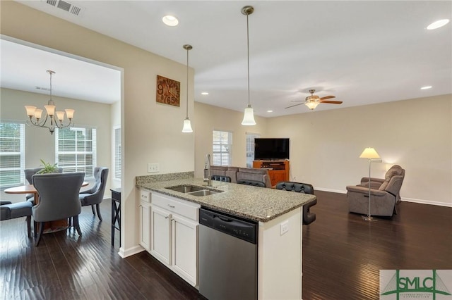 kitchen featuring light stone counters, a sink, visible vents, dark wood-style flooring, and dishwasher