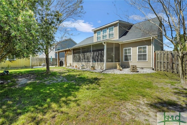 rear view of house featuring a lawn, a fenced backyard, and a sunroom