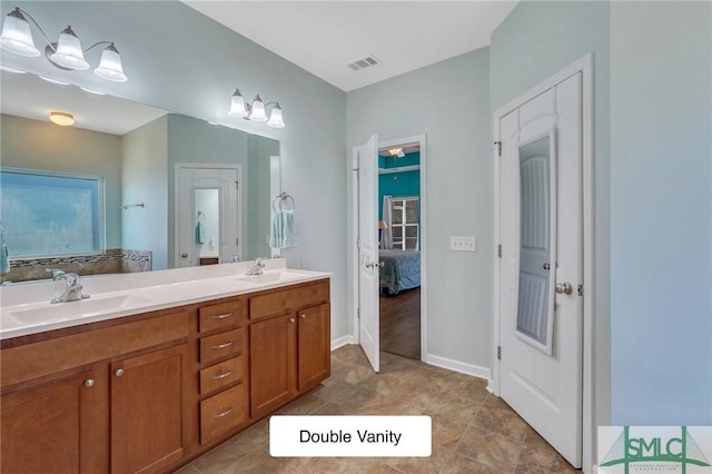 ensuite bathroom with visible vents, a sink, double vanity, and ensuite bathroom