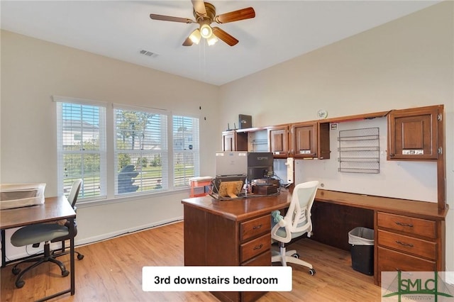 home office featuring visible vents, a ceiling fan, baseboards, and light wood-style floors