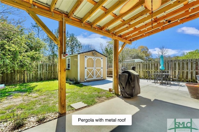 view of patio featuring an outbuilding, outdoor dining area, a storage unit, and a fenced backyard