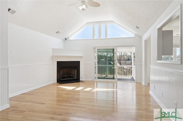 141 Runner Rd, Savannah, GA 31410 - unfurnished living room with a ceiling fan, light wood-style floors, lofted ceiling, a fireplace with flush hearth, and wainscoting