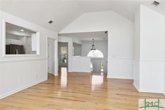 141 Runner Rd, Savannah, GA 31410 - unfurnished living room featuring a wainscoted wall, light wood finished floors, and lofted ceiling