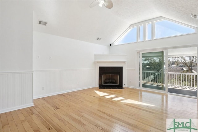 141 Runner Rd, Savannah, GA 31410 - unfurnished living room with wood-type flooring, ceiling fan, lofted ceiling, a tiled fireplace, and wainscoting