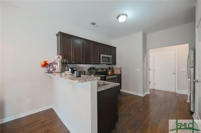 30 Walker Ct, Richmond Hill, GA 31324 - kitchen with appliances with stainless steel finishes, a peninsula, dark wood-style floors, visible vents, and dark brown cabinets