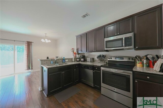 30 Walker Ct, Richmond Hill, GA 31324 - kitchen with visible vents, a peninsula, stainless steel appliances, dark wood-type flooring, and an inviting chandelier
