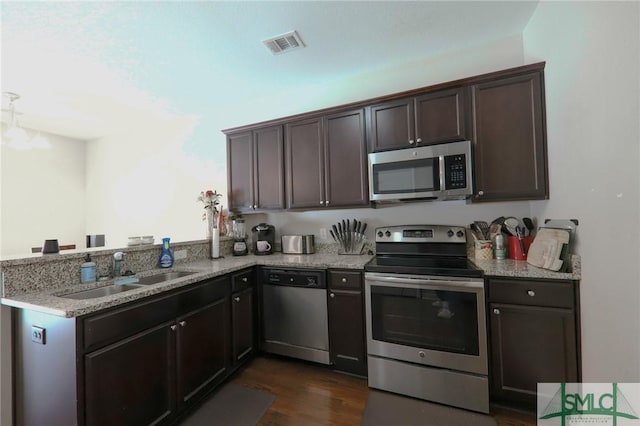 30 Walker Ct, Richmond Hill, GA 31324 - kitchen featuring dark brown cabinetry, a sink, appliances with stainless steel finishes, a peninsula, and visible vents