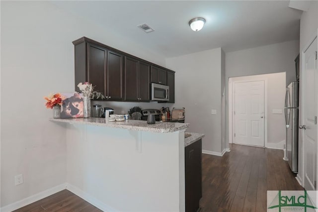 30 Walker Ct, Richmond Hill, GA 31324 - kitchen with a kitchen breakfast bar, dark wood finished floors, a peninsula, dark brown cabinets, and appliances with stainless steel finishes