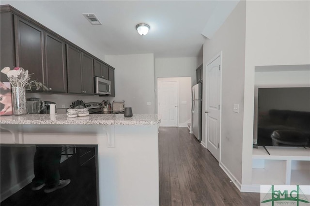 30 Walker Ct, Richmond Hill, GA 31324 - kitchen with appliances with stainless steel finishes, a peninsula, dark wood-style floors, visible vents, and dark brown cabinets