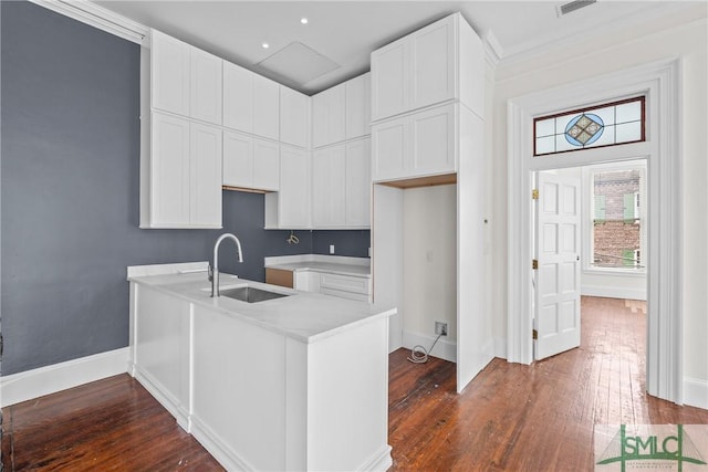 417 Whitaker St, Savannah, GA 31401 - kitchen featuring a sink, dark wood-style floors, baseboards, and white cabinets