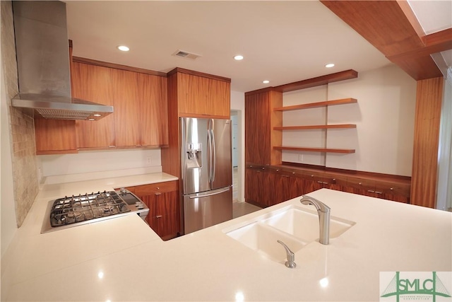 kitchen featuring a sink, open shelves, visible vents, stainless steel refrigerator with ice dispenser, and wall chimney range hood