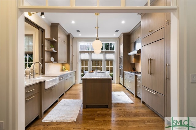 5091/2 Tattnall St, Savannah, GA 31401 - kitchen with open shelves, ornamental molding, a center island with sink, a sink, and wood finished floors