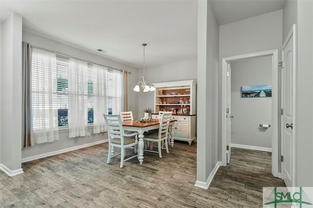 95 Glen Way, Richmond Hill, GA 31324 - dining space featuring wood finished floors, a chandelier, and baseboards