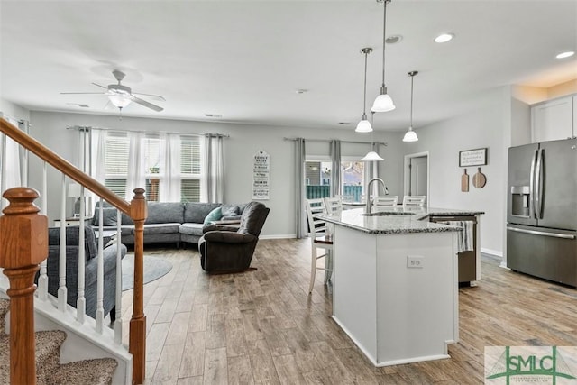 95 Glen Way, Richmond Hill, GA 31324 - kitchen with stainless steel refrigerator with ice dispenser, a sink, ceiling fan, light wood-type flooring, and an island with sink