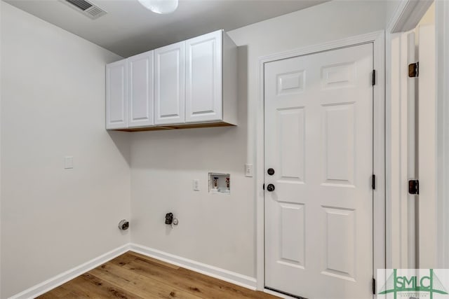 laundry area with wood finished floors, cabinet space, baseboards, visible vents, and washer hookup