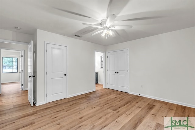 unfurnished bedroom with ceiling fan, baseboards, light wood-style floors, and visible vents