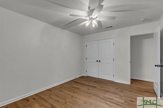 unfurnished bedroom with baseboards, light wood-style flooring, visible vents, and a closet
