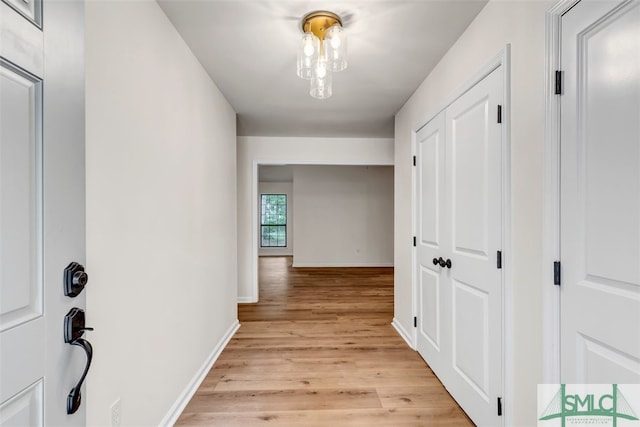 hall featuring baseboards and light wood-type flooring